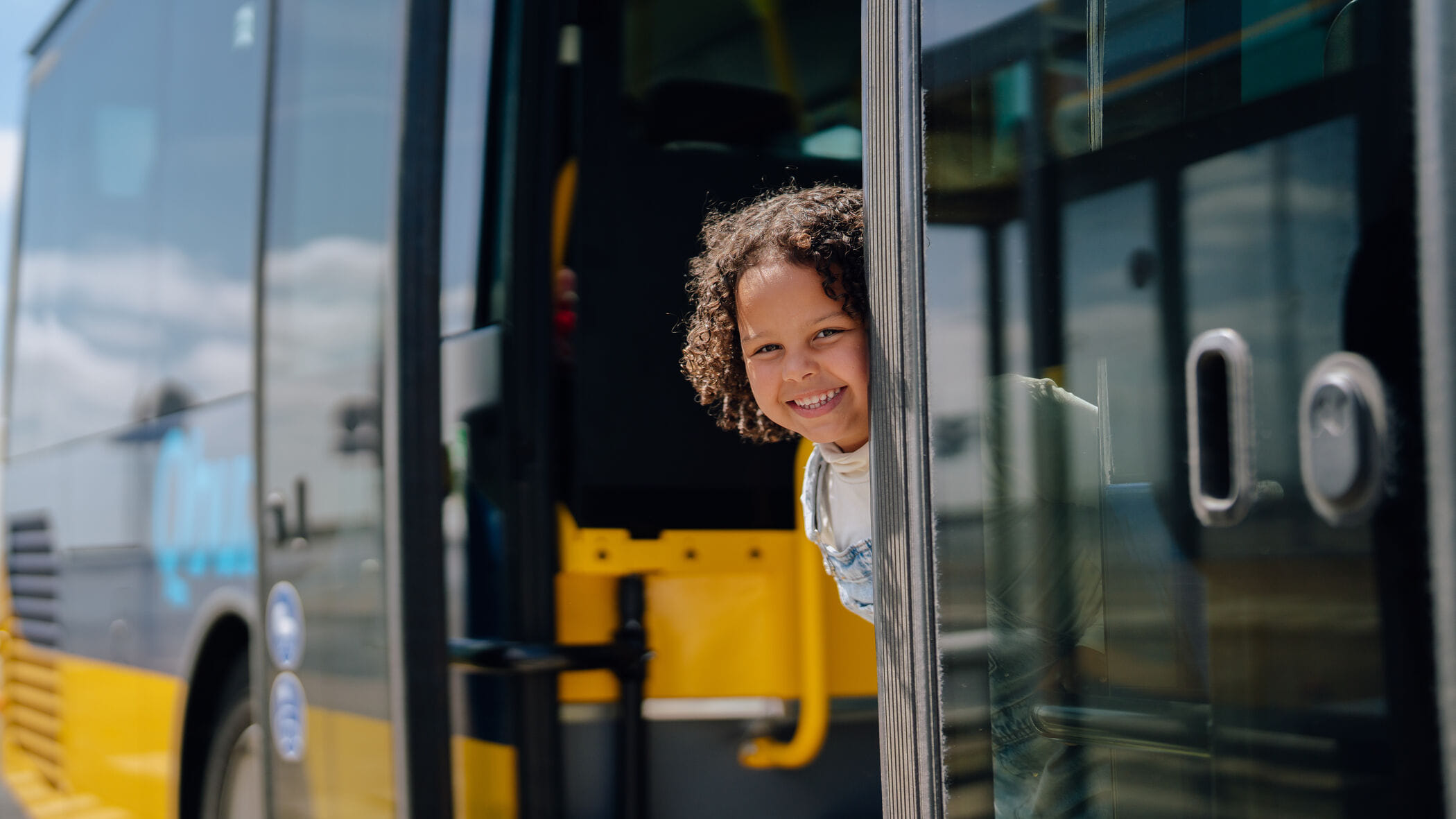 Klein kind kijkt glimlachend bij de deuropening naar buiten